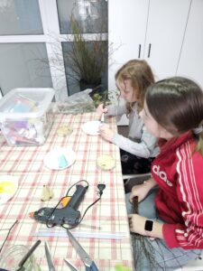 20260330_160244 Dwie dziewczynki pracujące na warsztatach wielkanocnych.