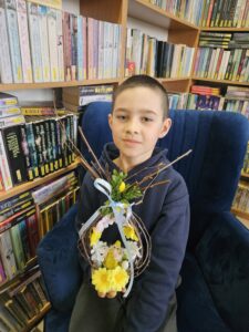 20260330_164043 Chłopiec z wielkanocnym stroikiem.