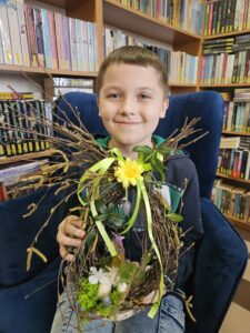 20260330_164608 Chłopiec z wielkanocnym stroikiem.