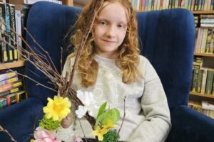 Dziewczynka z wielkanocnym stroikiem.