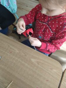 Dziewczynka podczas warsztatów robienia tulipanów z papieru.