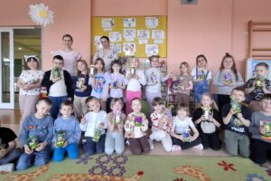 Dzieci i prowadzący zajęcia wraz z wykonanymi pracami - zdjęcie grupowe