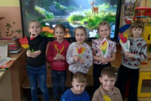 Grupa dzieci z papierowymi tulipanami w rękach.