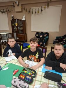 Trzej chłopcy podczas warsztatów plastycznych.