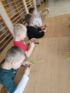 Chłopcy wykonujący zakładki do książek.