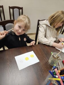 Dwie dziewczynki rysujące kredkami.