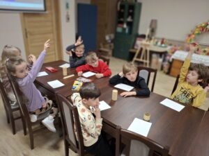 Grupa dzieci rysujących kredkami.