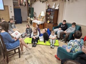 Dzieci słuchające czytanej książki przez kobietę,