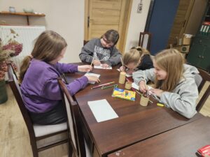 Dziewczynki rysujące na kartkach kredkami.