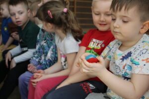 Dzieci oglądające malutką książeczkę.