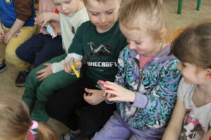 Dzieci oglądające malutką książeczkę.