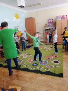 Dzieci i kobieta podczas zabaw ruchowych.