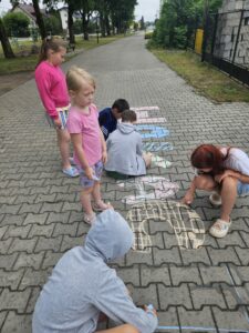 20260702_092717 Dzieci rysujące kredą po kostce.