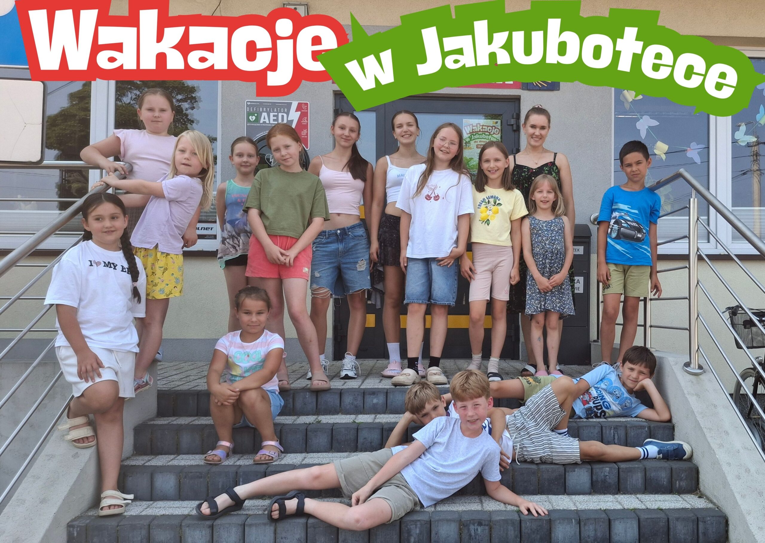 Wakacje(2) Grupa dzieci stojących na schodach przed biblioteką. Nad nimi napis: Wakacje w Jakubotece