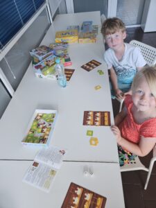 Dziewczynka i chłopiec grający w gry planszowe.