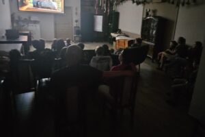 Ludzie oglądający projekcję na dużym ekranie.
