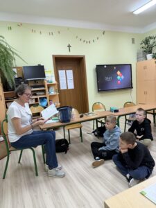 IMG_0134 Kobieta czyta dzieciom książkę.