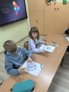 IMG_0137 Dzieci wyklejają sznureczkami kształt sweterka na kartce.